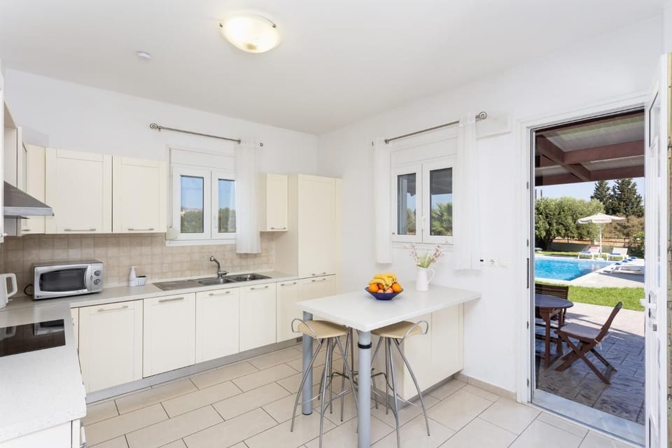 Equipped kitchen with dining area and terrace access