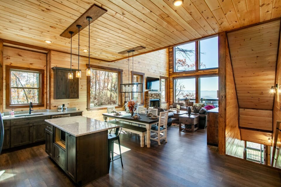 Blending functionality with beauty: this open-concept cabin design offers a seamless flow between the kitchen, dining, and living areas.