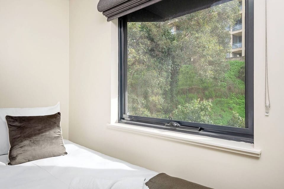 The large window invites in natural light and offers a tranquil backdrop, ensuring a peaceful start to your day or a quiet retreat after exploring the city.