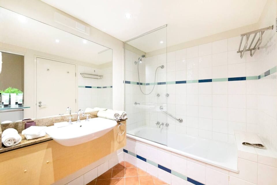 The tiled ensuite bathroom features a shower and bathtub.