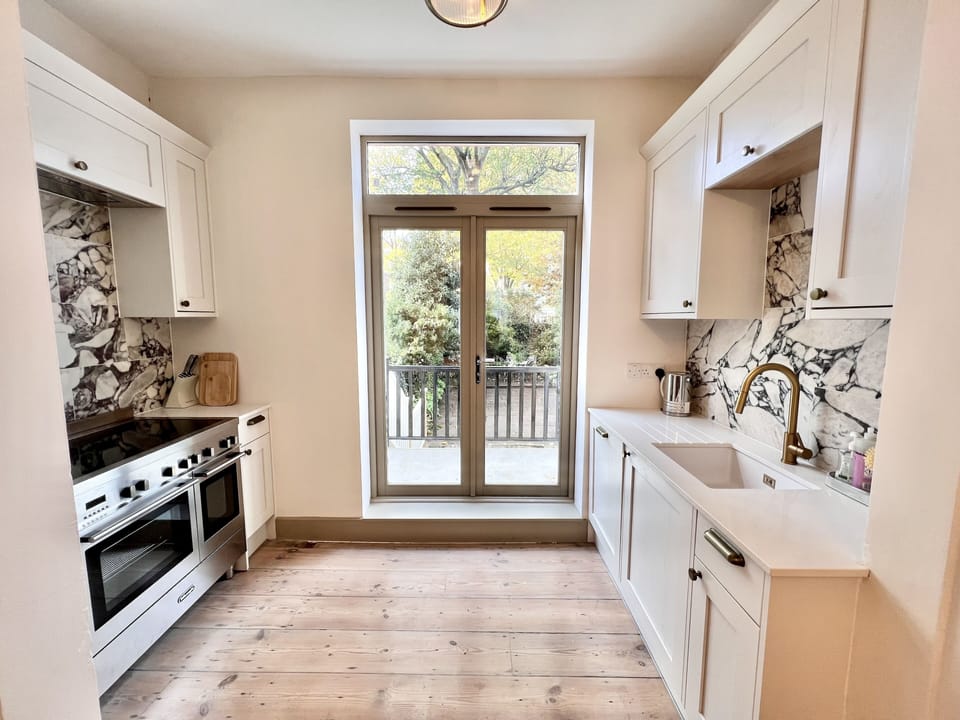 kitchen with double induction stove and French doors to the private garden