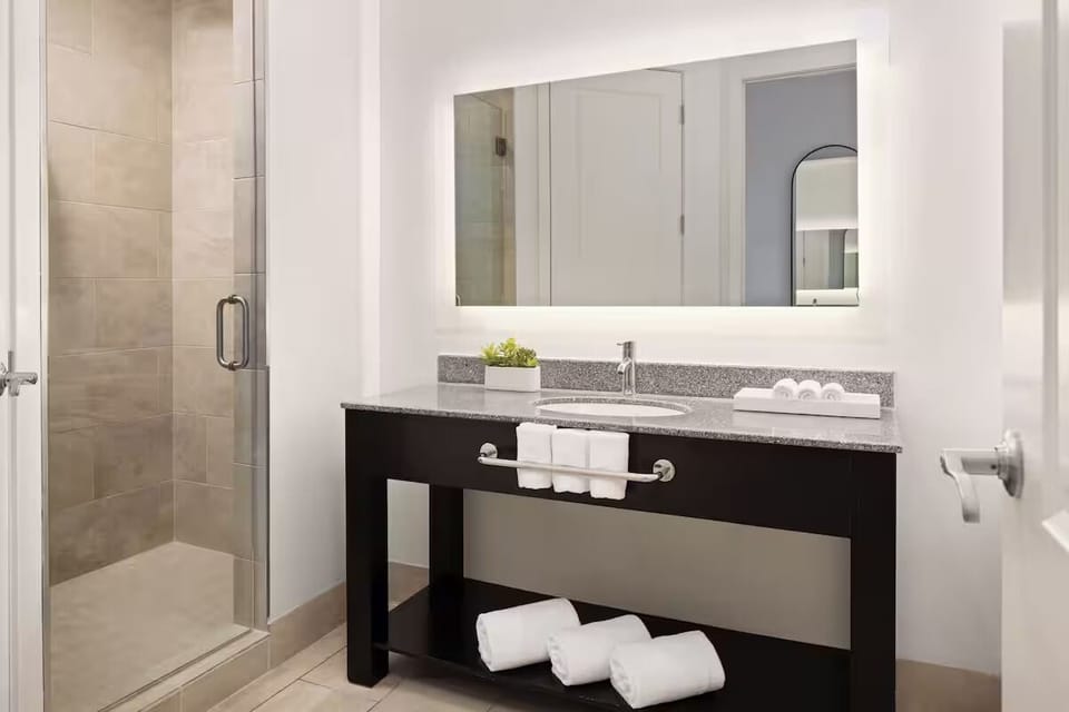 Refresh in a spotless bath with bright vanity lighting.