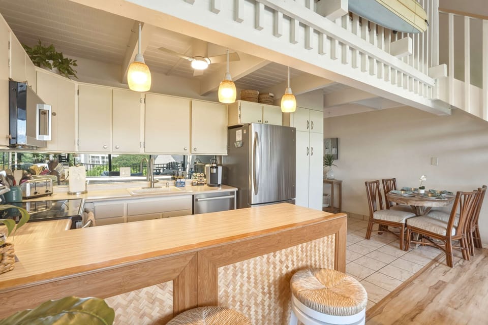 Enjoy cooking and dining in your fully equipped, open-concept kitchen featuring stainless steel appliances, a spacious breakfast bar, and an adjacent dining area.