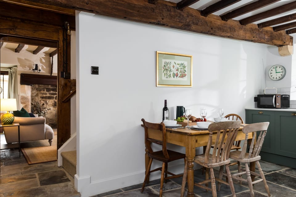 The dining area of the kitchen leading to the sitting room and stairs to the first floor