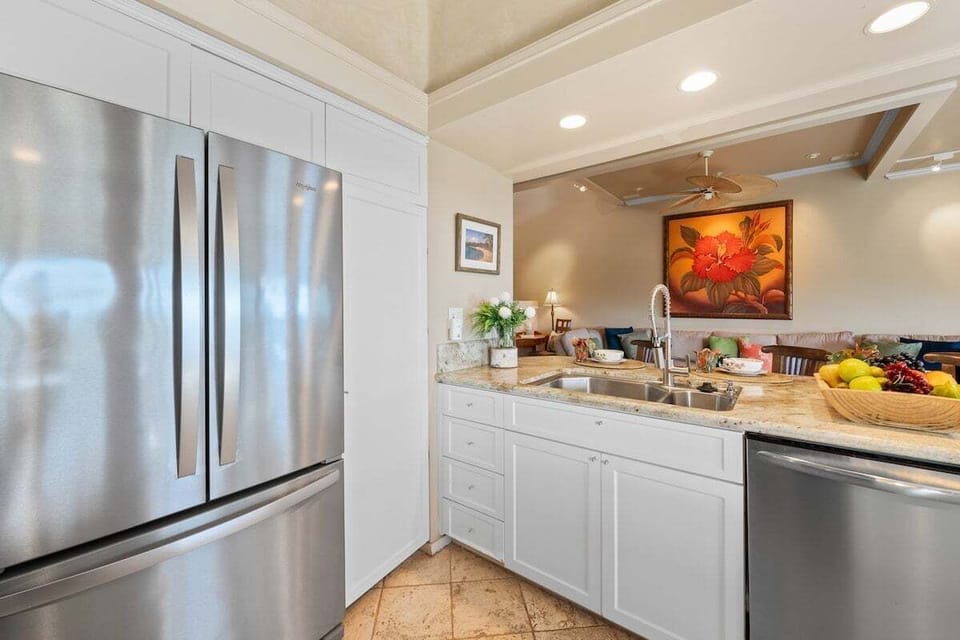 Spacious remodeled kitchen with stainless refrigerator, ample cabinetry, and modern finishes designed for comfort and functionality.