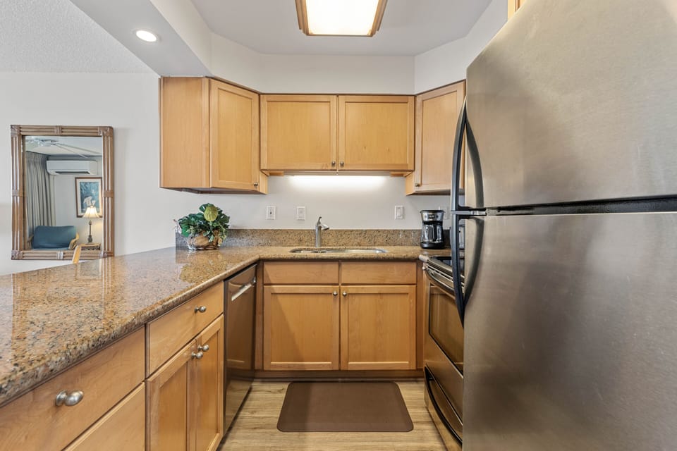 Fully stocked kitchen features granite countertops and stainless steel appliances