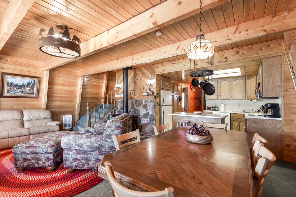 Relax in the cozy living room of Henry's Hatch Cabin, featuring plush furnishings and lake views, creating the perfect atmosphere for unforgettable moments with loved ones.