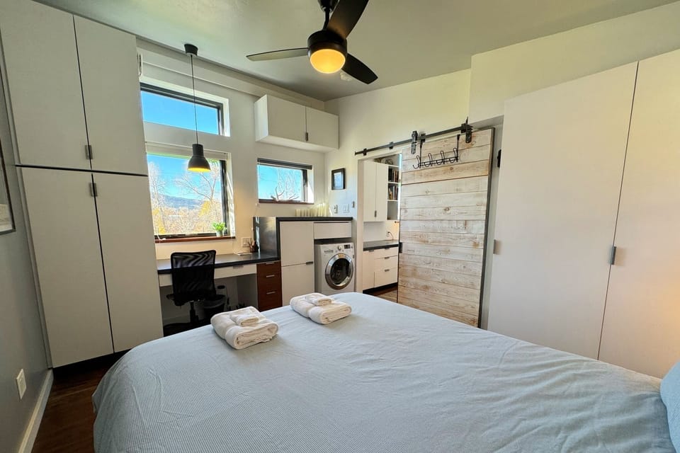 The bedroom enjoys a queen bedroom, loads of storage space, a workspace, and laundry machines.