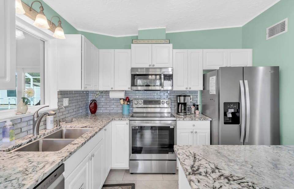 The kitchen is stocked with appliances like a dishwasher, microwave, refrigerator, stove top oven, and a traditional drip coffee maker.