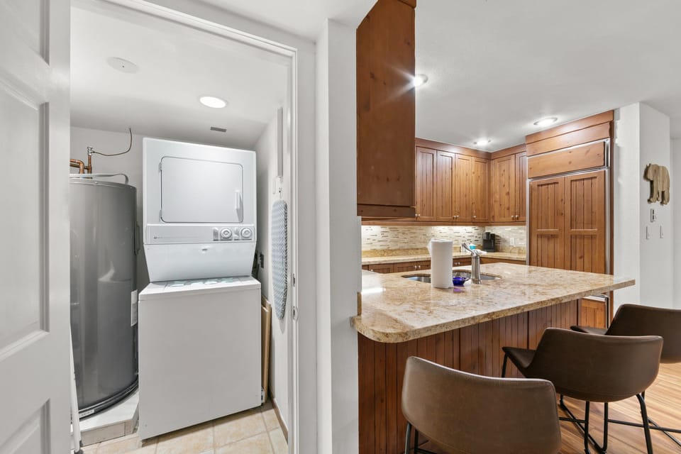 Your kitchen features warm wood cabinets and granite counters, with convenient in-unit laundry just steps away.