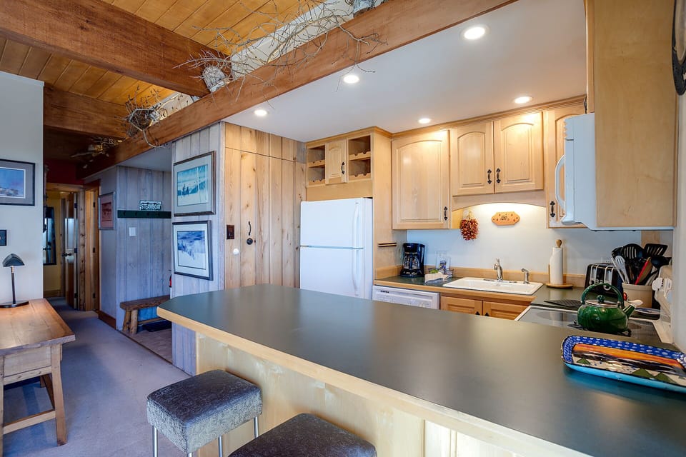Your rustic yet modern kitchen blends exposed beams with sleek countertops, creating the perfect space for preparing memorable meals.