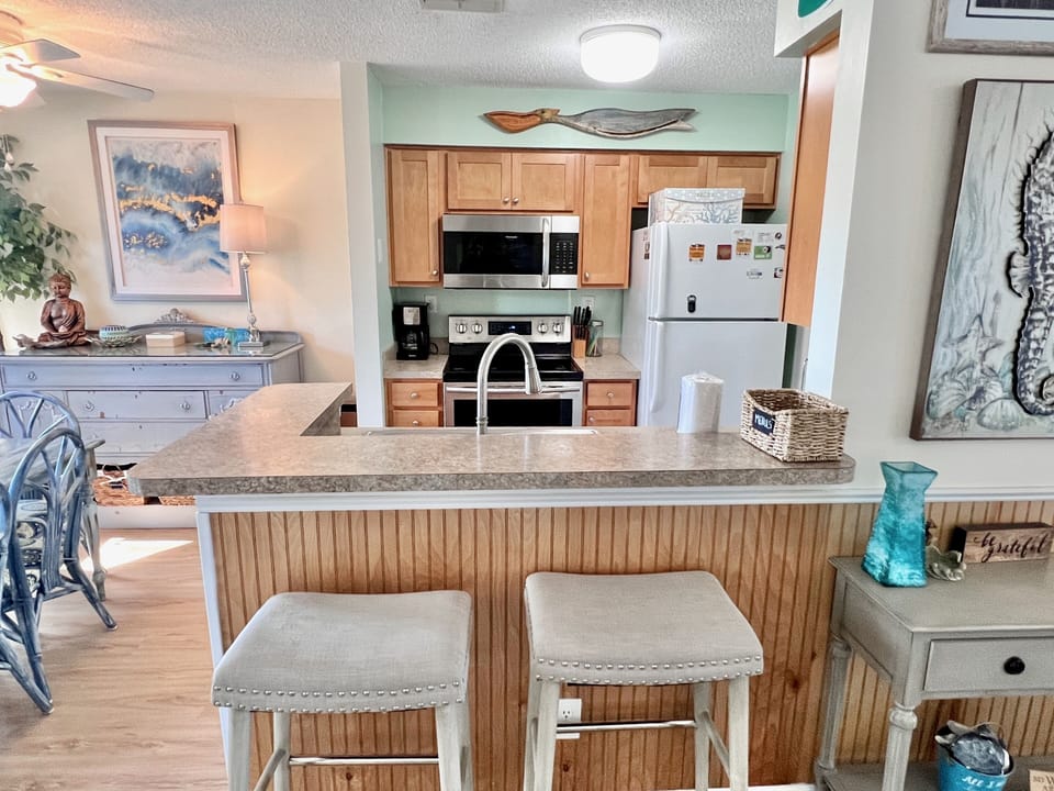 Kitchen - Well-appointed kitchen featuring lots of counter space, upgraded appliances, and a breakfast bar, ideal for preparing home-cooked meals.