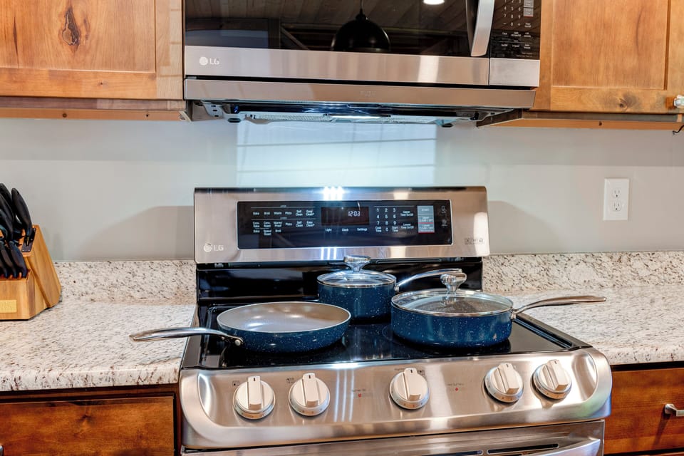 Professional cookware collection showcased on premium dual-oven range for culinary enthusiasts