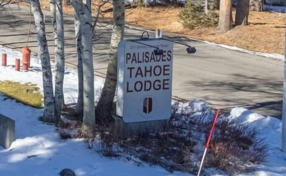 Palisades Tahoe Lodge welcomes guests to a premier mountain destination surrounded by snow-covered landscapes and towering pines.