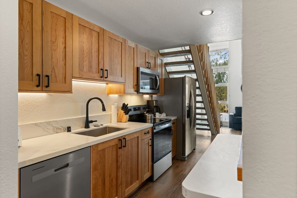 Your fully equipped kitchen features warm wood cabinetry, granite counters, and stainless steel appliances for memorable meal preparation.