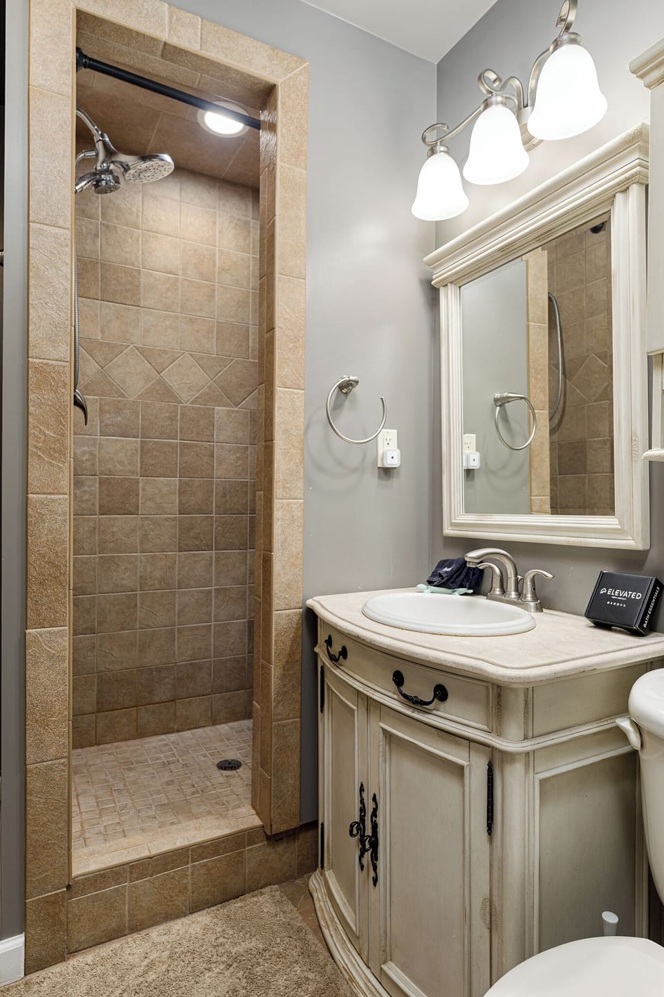 Bright bathroom w/ tiled shower & classic vanity for easy mornings.