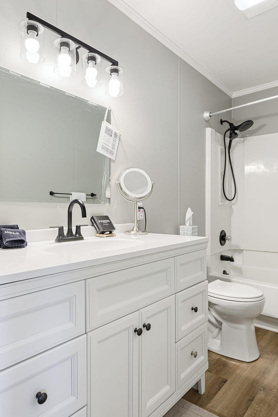 Clean bathroom featuring a sleek vanity, sink, & glass-enclosed shower.