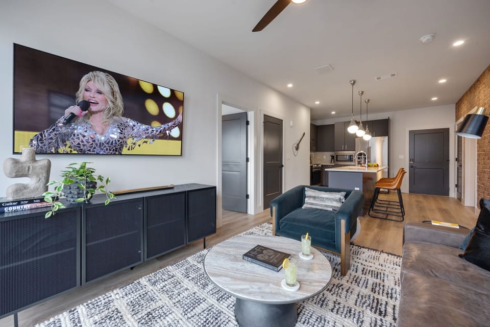 Bright living room with comfortable seating, smart TV, designer decor, and access to the private patio.