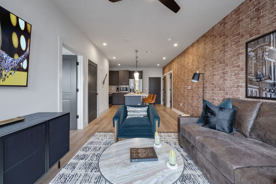Bright living room with comfortable seating, smart TV, designer decor, and access to the private patio.
