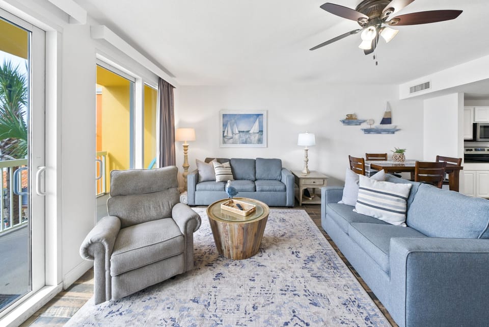 Sink into plush blue sofas while gentle ceiling fans keep you cool in this bright, open living space.