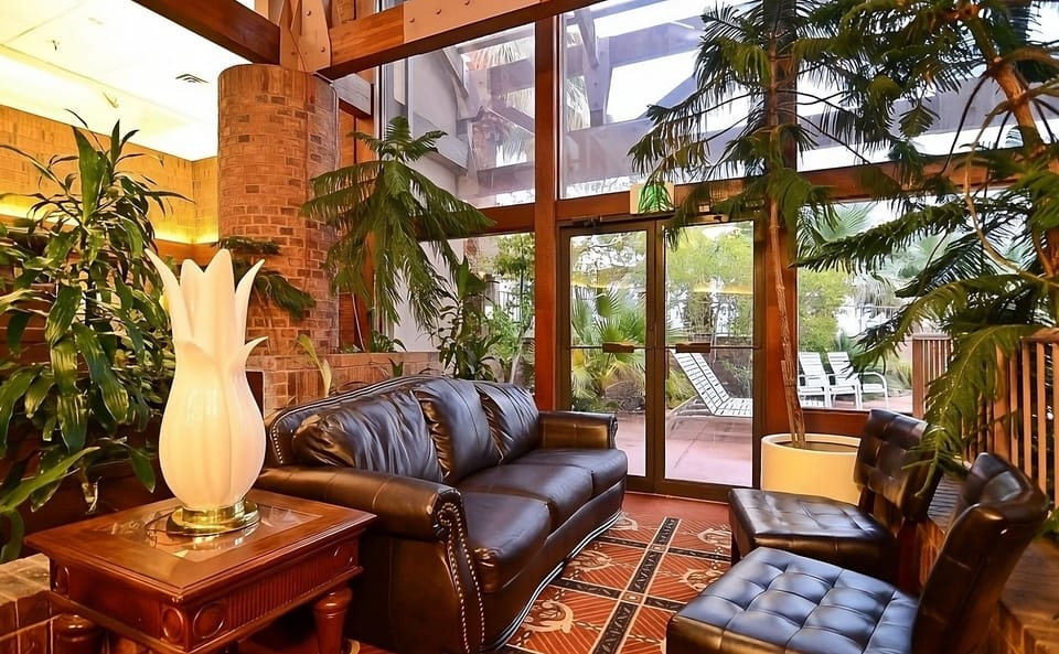 Unwind beneath soaring windows surrounded by lush indoor greenery.