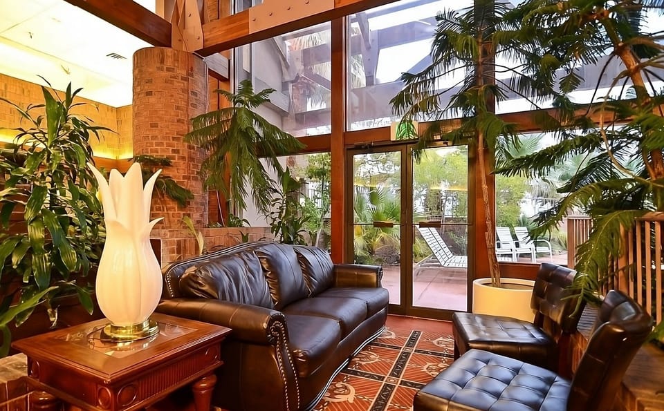 Unwind beneath soaring windows surrounded by lush indoor greenery.