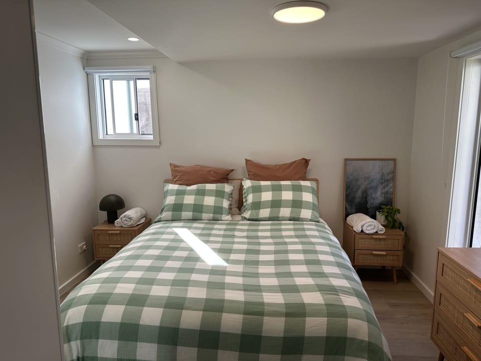 Main bedroom queen bed with bedside tables and hanging rack 