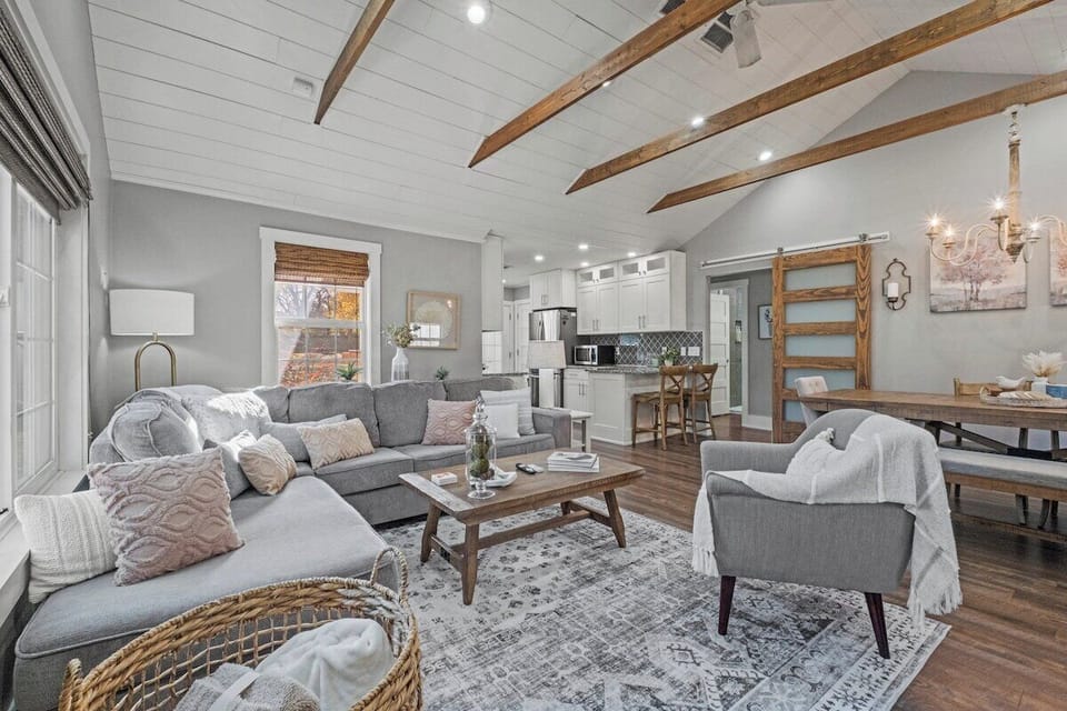 Stylish living room with seamless flow into the dining area, offering plenty of space to unwind during your stay in the quiet neighborhood of Mission, Kansas.