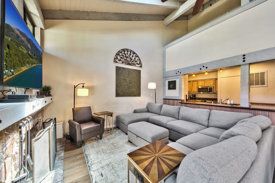 Sink into this plush sectional sofa and unwind in your stylish living space, complete with exposed beams and modern kitchen access.