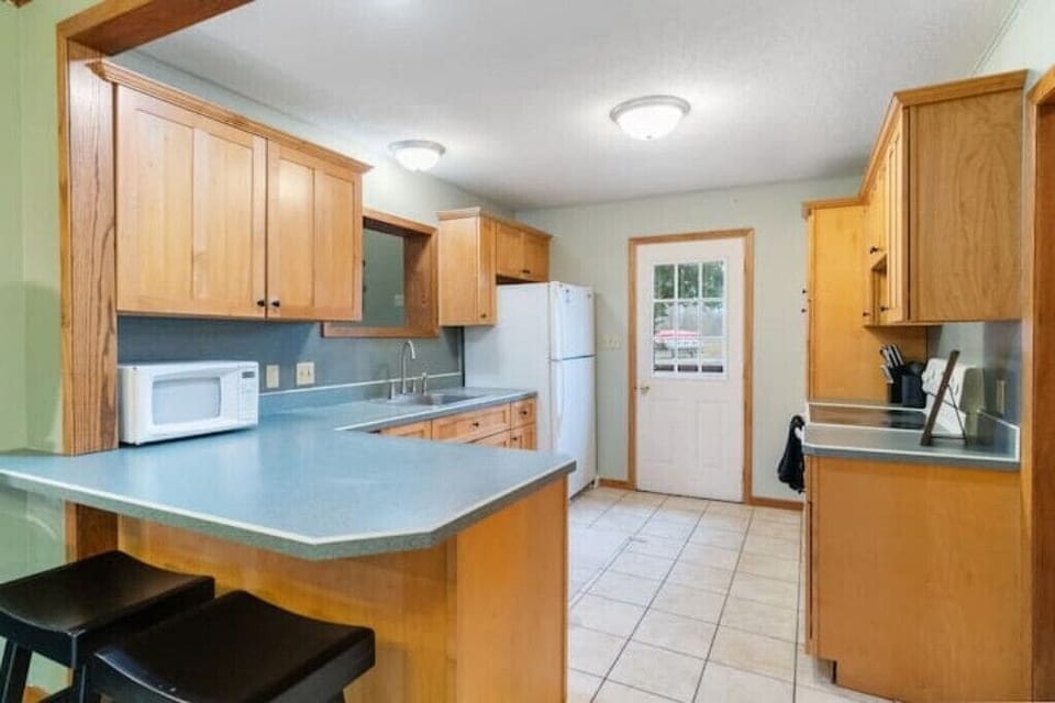 Open kitchen w/ a range, fridge, freezer, microwave, toaster, & electric griddle