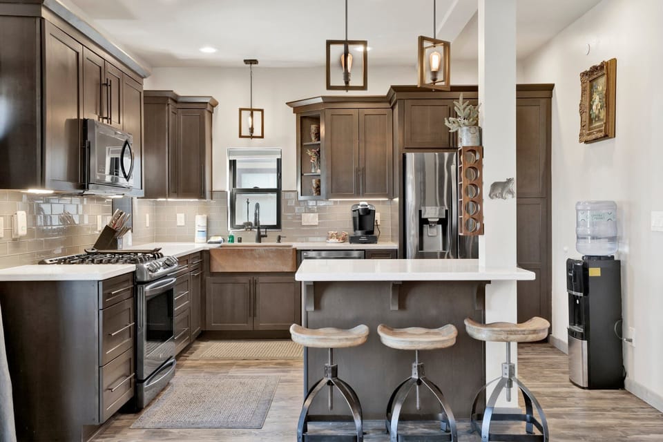 Fully equipped cabin kitchen with ample cabinetry, stove, fridge, microwave, and coffee maker perfect for cooking meals, morning coffee, and feeling right at home on your stay.
