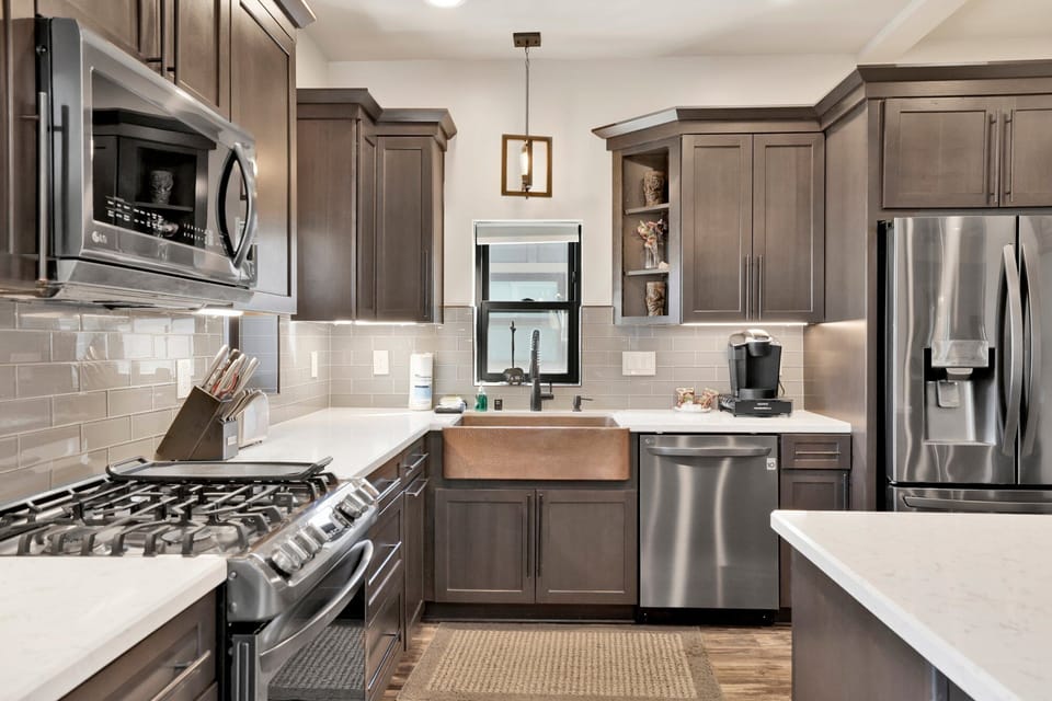 Fully equipped cabin kitchen with ample cabinetry, stove, fridge, microwave, and coffee maker perfect for cooking meals, morning coffee, and feeling right at home on your stay.