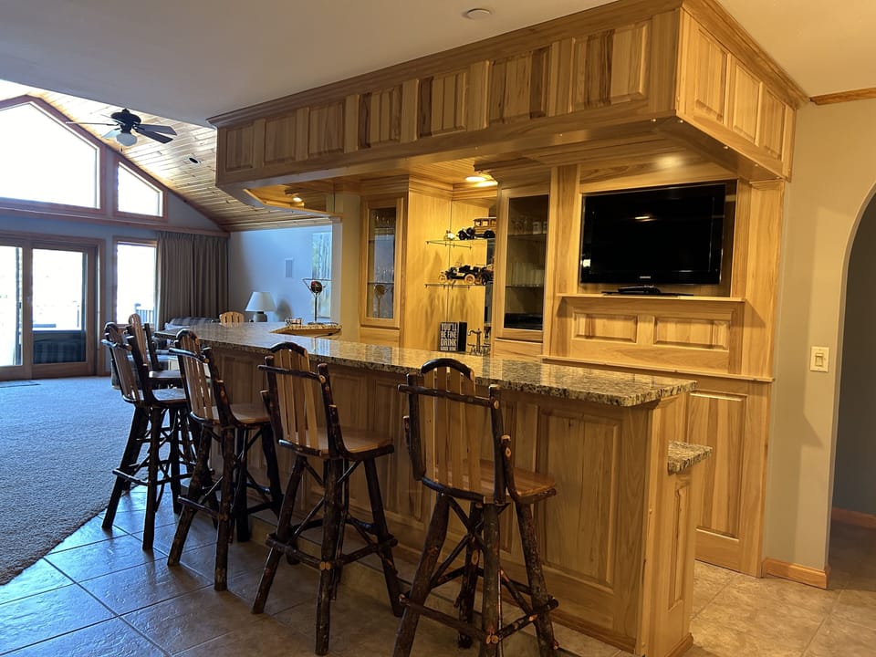 bar for 6 + bartenders, wine fridge, beer fridge, TV, whole house audio and sink