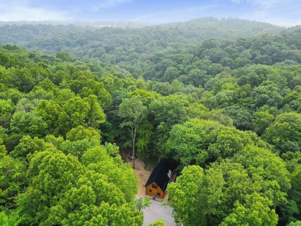 A peaceful cabin surrounded by trees and rolling hills, perfect for a quiet escape!