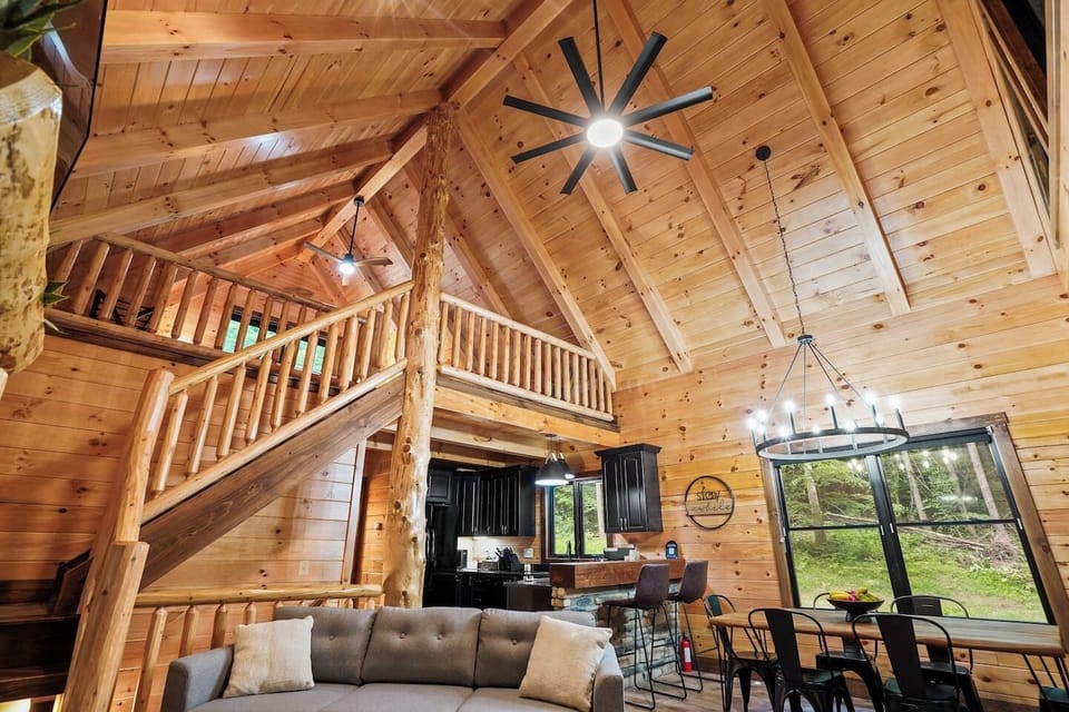 Living space featuring a stone fireplace, cozy seating, and rustic wood interiors.