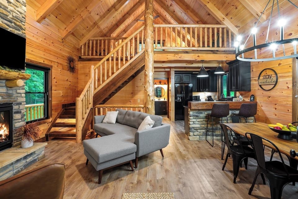 Living space featuring a stone fireplace, cozy seating, and rustic wood interiors.