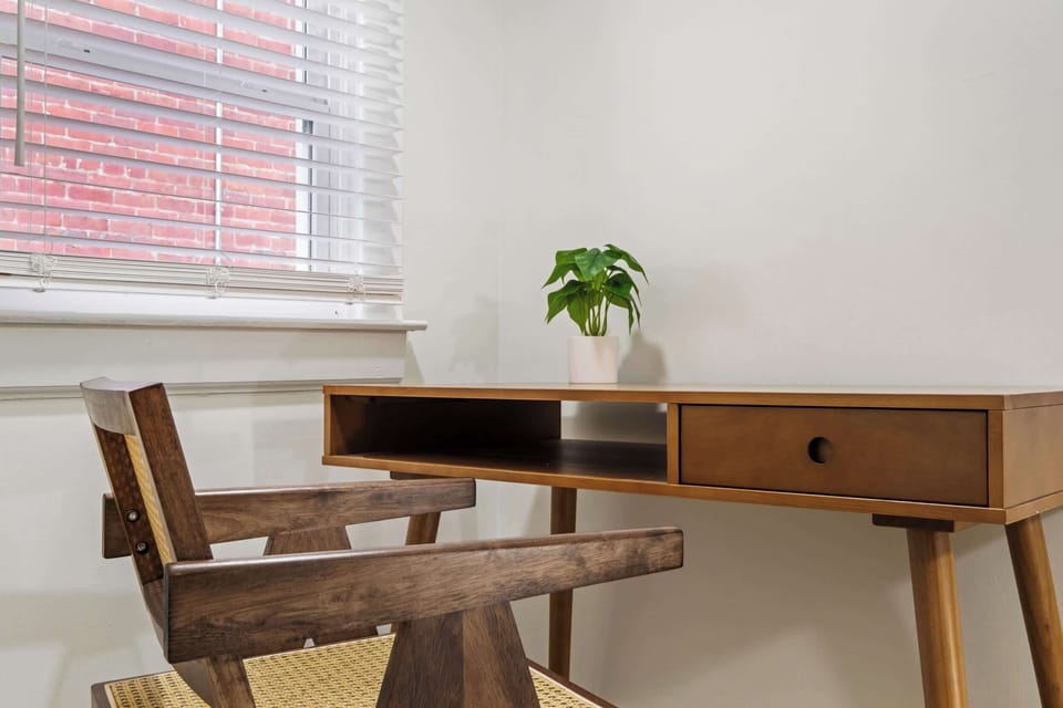 Bedroom 1: Rest easy in our attic bedroom featuring a cozy bed, soft carpeting, and a snug reading nook with a sofa—perfect for a peaceful night's sleep.