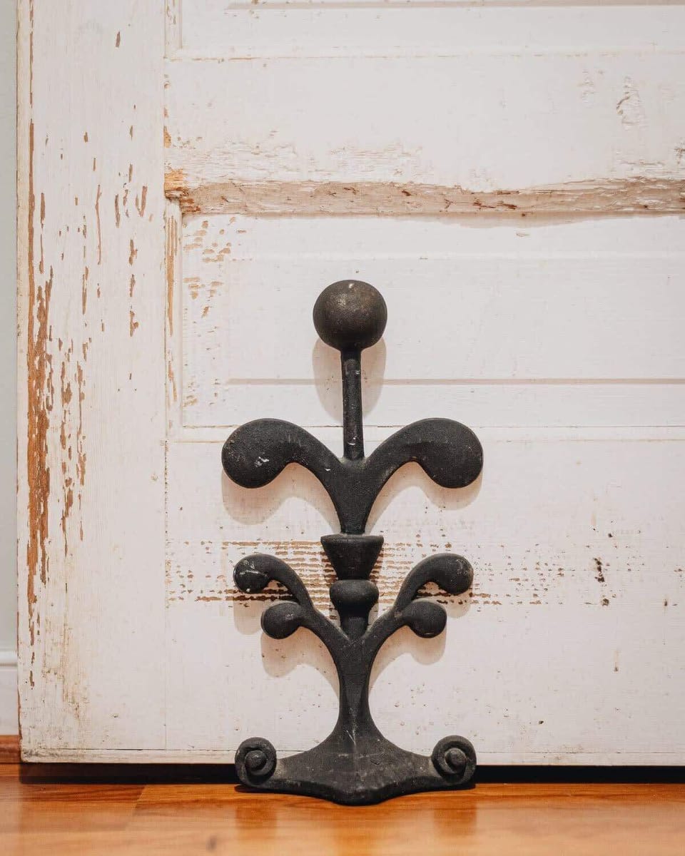 More whimsey! We love this old door out to the screened porch and the iron door stopper.