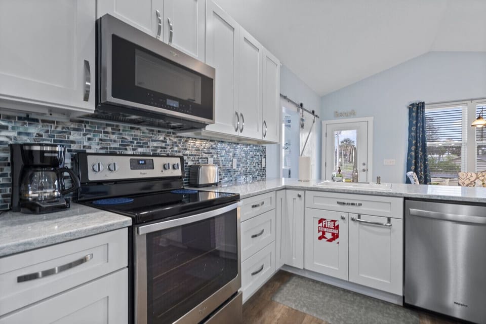 Modern stainless steel appliances and pristine white drawers and cabinets sets off this kitchen to perfection