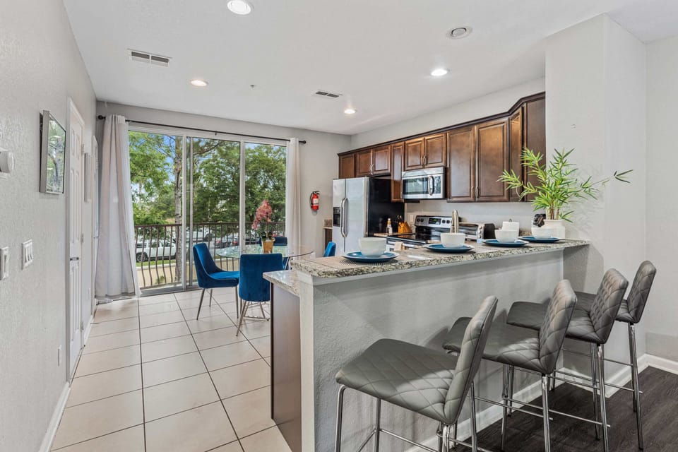 - Fully equipped kitchen of the townhouse in Orlando Florida - Marvelously designed breakfast bar with high chairs - availability of stainless steel appliances and all necessary accessories - Plenty of space to work according to your ease