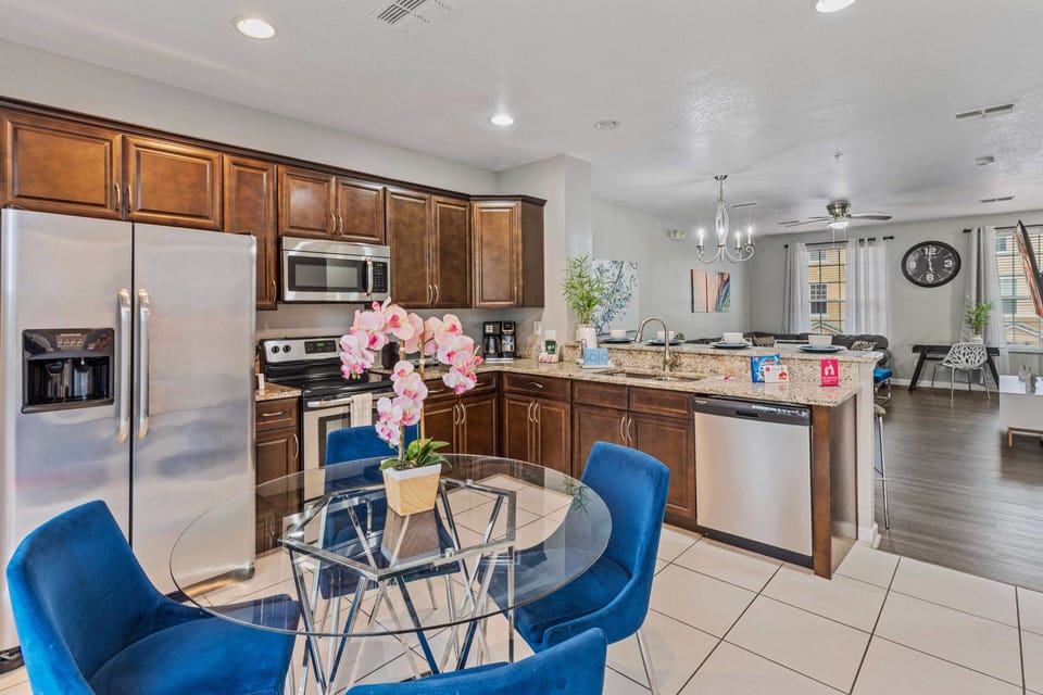 - Fully equipped kitchen of the townhouse in Orlando Florida - Features modern stainless steel appliances - Breakfast bar and high chairs - Open concept kitchen with plenty of space to work with ease - Sublime 4 persons dinning table within kitchen