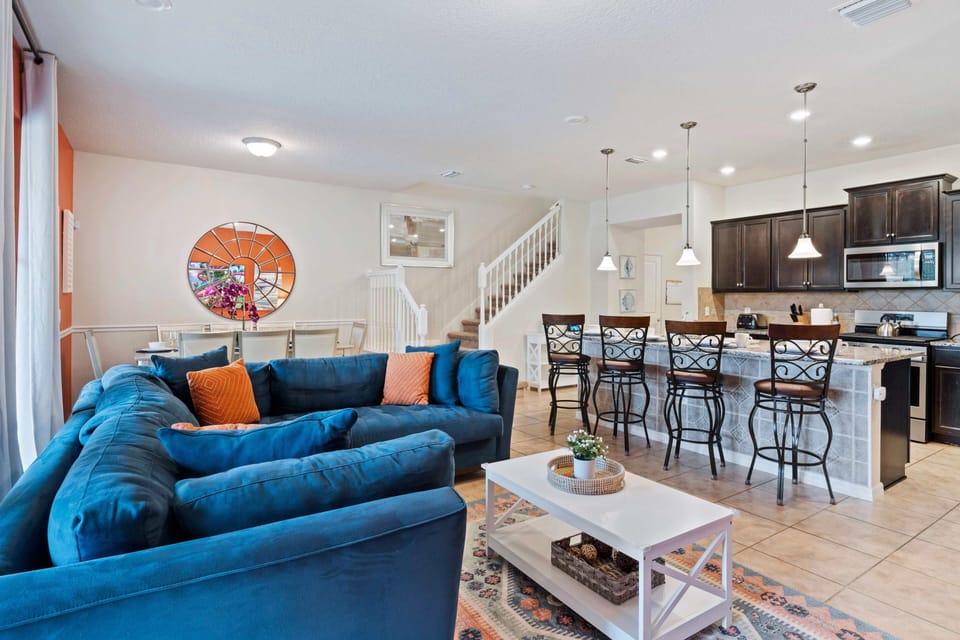 Experience the lively ambiance of our living room retreat, offering vibrant décor and generous seating for enjoying shows, movies, games, and more. Plus, enjoy easy access to the pool for added relaxation.