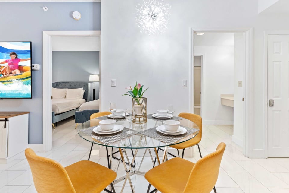 Living room with large smart TV, sleeper sofa and kitchen