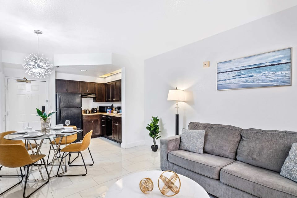 Living room with large smart TV, sleeper sofa and kitchen