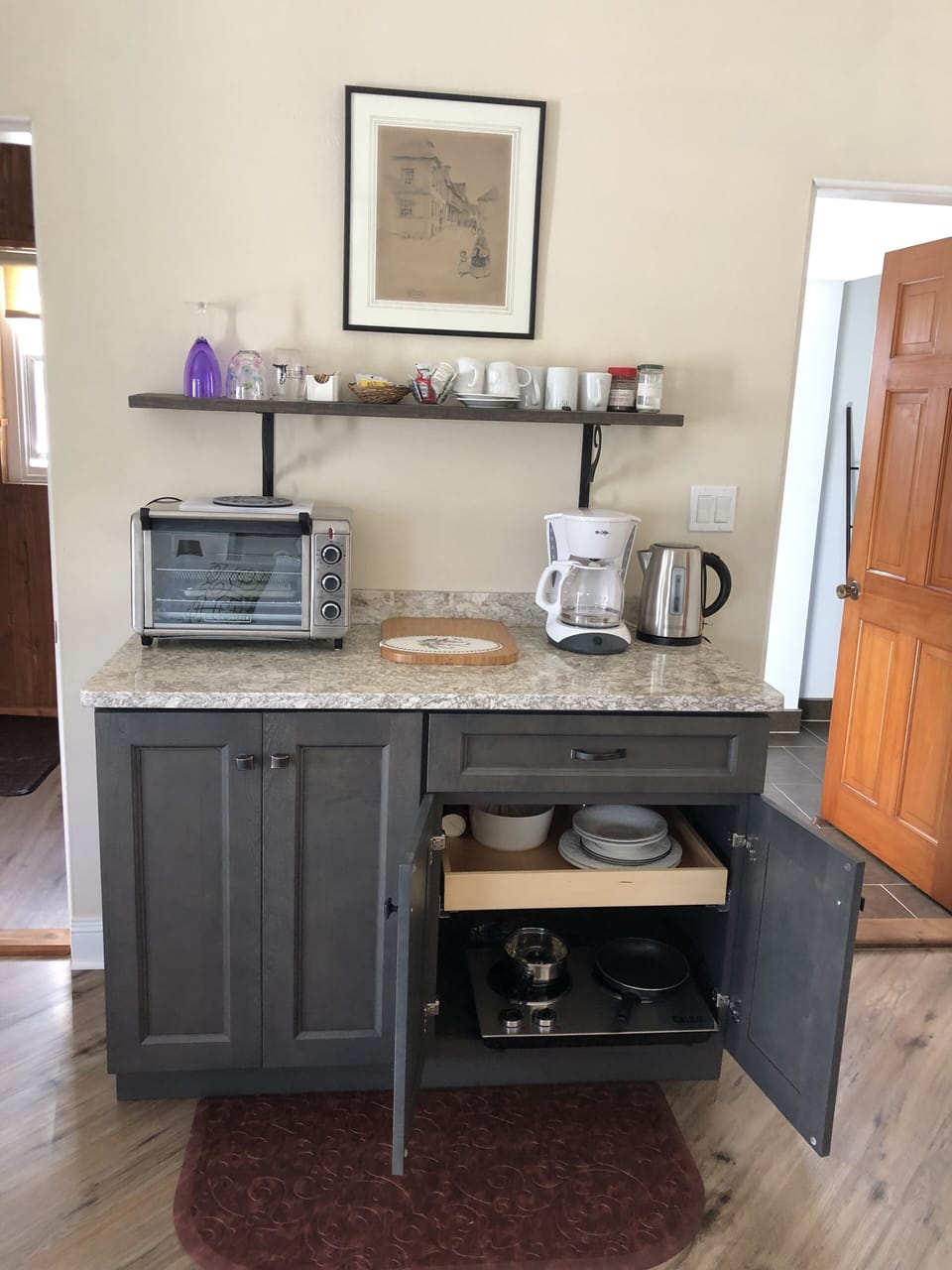 Small kitchenette with microwave, toaster oven, coffee pot and kettle.