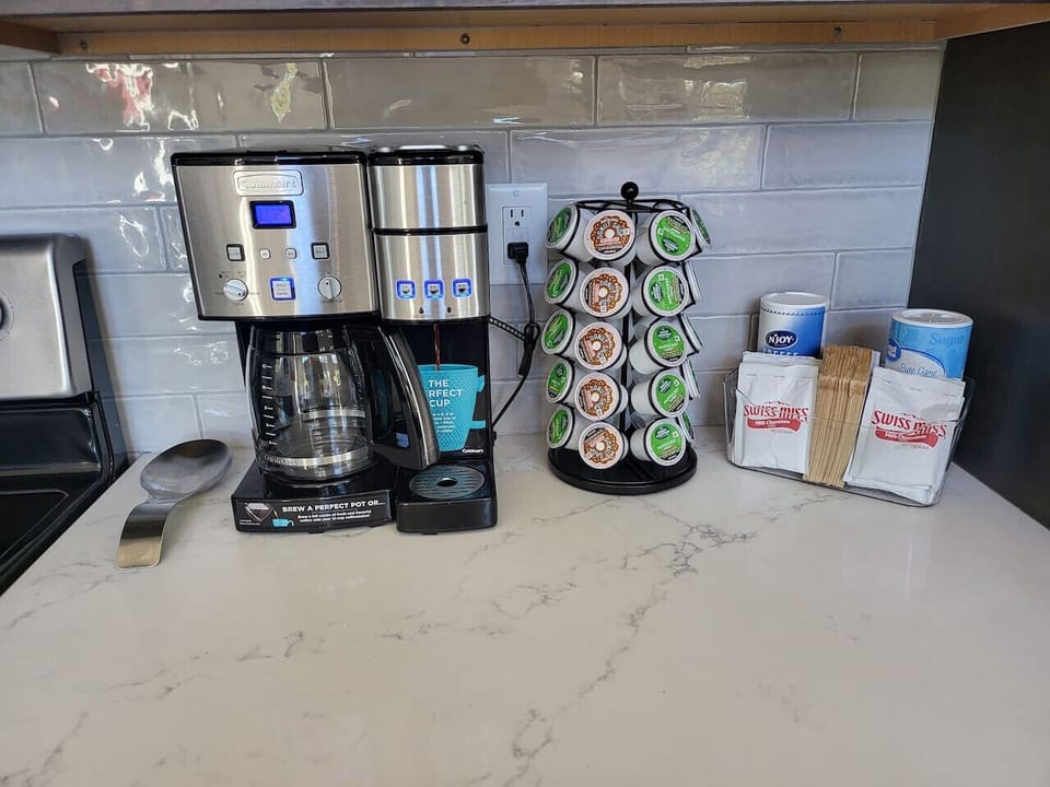 Coffee station with K cups, ground coffee, and cream and sugar.