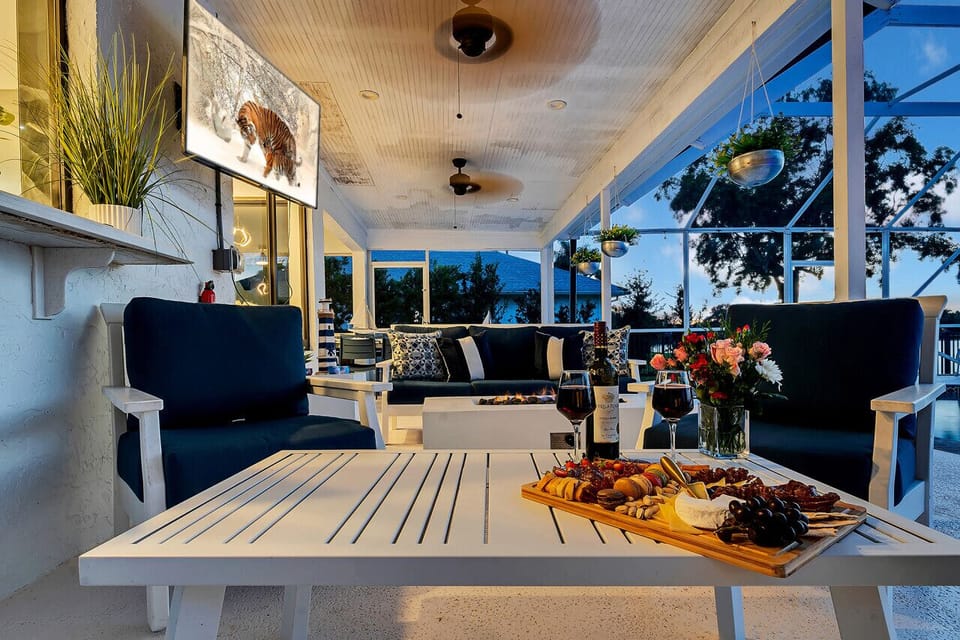 Screened-in outdoor pool patio w smart TV & ample lounge furniture