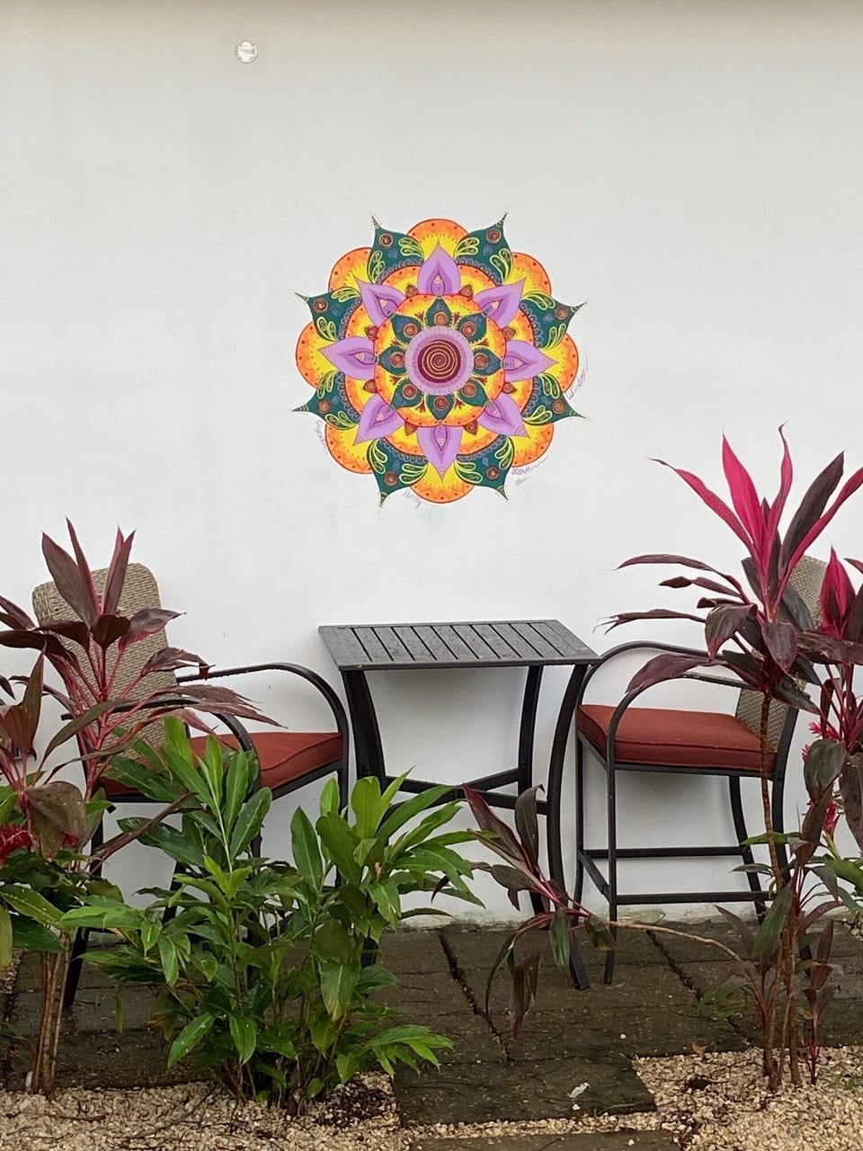 Mural on side of casita with outside sitting / dining table and chairs