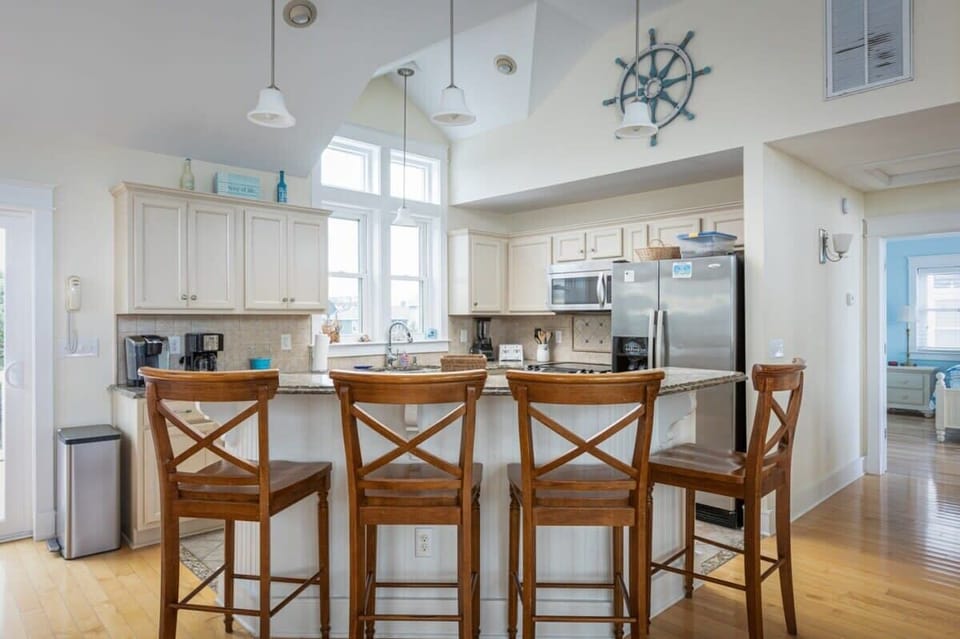 Fully Equipped Kitchen with a Refrigerator, Stove, Oven,Diswasher, Coffee Maker, Breakfast Bar Seating, and Tall Windows that Bring in Natural Daylight