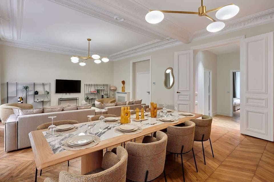 Salon avec 2 canapés lits, cuisine américaine entièrement équipée et grande table pour diner